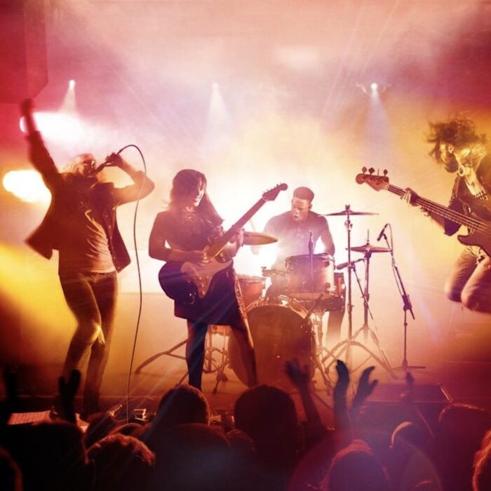 Bright stage lights over a performing team, suggesting momentum and continuous practice